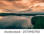 Tranquil sunset over Lake Keitele in Central Finland, where golden skies reflect on calm waters surrounded by lush forests. A serene escape into Finnish nature, perfect for relaxation and inspiration.