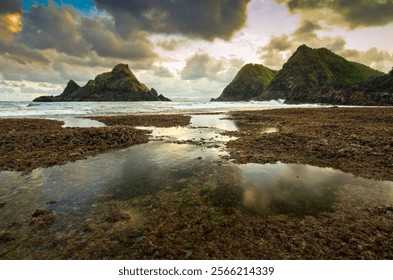 Tranquil Tide Pools Reflect Dramatic Clouds and Coastal Hills at Sunset at Telawas Beach Lombok Indonesia