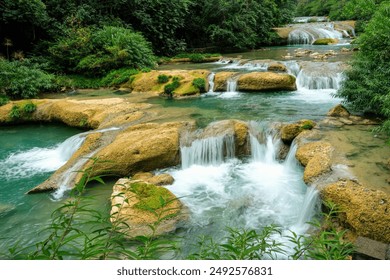 Tranquil Waterfalls Flowing Over Rocky Terrain in Lush Greenery   - Powered by Shutterstock