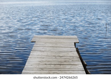 Tranquil Wooden Pier Extending Over Serene Blue Lake in Daylight - Powered by Shutterstock