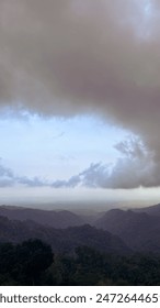 “Embracing the tranquility of the mountains beneath the vast, brooding sky.”
