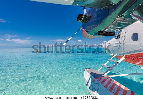 Trans Maldivian Airways Twin Otter seaplanes at\
Male airport. Exotic scene with Trans Maldivian Airways seaplane on\
Maldives sea landing. Vacation or holiday in Maldives summer\
vacation