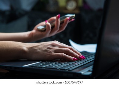 Transactions on your mobile phone and laptop. The woman checks the bank code, information needed to use the laptop. Online shopping, bank transfers, bank security concept.