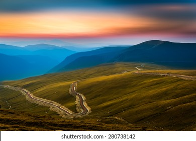 Transalpina road. Transalpina is one of the highest roads passing the Carpathians in Romania. Layers of haze cover the mountains peaks at sunset.