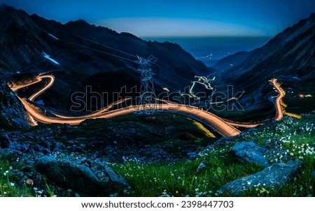 Transfagarasan road with light trails after sunset and the Milky Way on the night sky