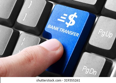 Transfering Online. Gesture Of Finger Pressing Bank Transfer Button On A Computer Keyboard