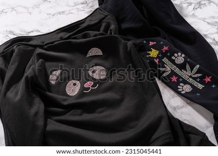 Transfering rhinestone pattern into the figure skating practice clothes with an iron.