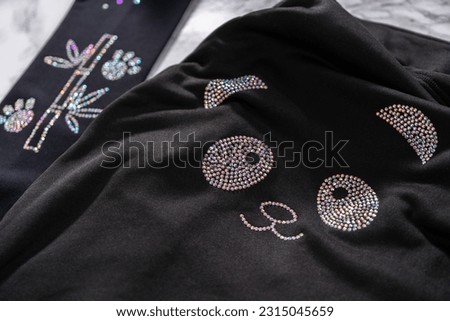 Transfering rhinestone pattern into the figure skating practice clothes with an iron.