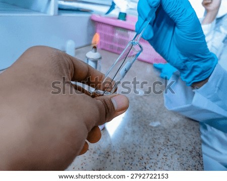 Transferring microbial culture using inoculating loop in microbiology laboratory.