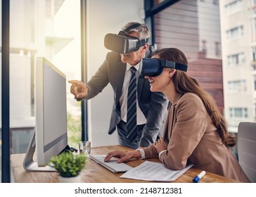 Transferring their ideas through new dimensions. Shot of two businesspeople wearing VR headsets while working on a computer in an office. - Powered by Shutterstock