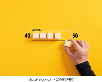 Transformation of wireless network connection technology from 4G to 5G. Hand places a wooden cube to the loading bar with the words 4G and 5G.