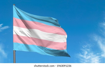 Transgender flag waving against blue sky  transgender pride flag in street
