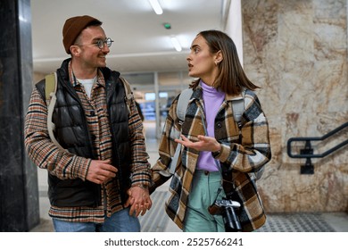 In transit and full of stories, two travelers engage in a lively discussion while navigating the steps of a bustling station. - Powered by Shutterstock