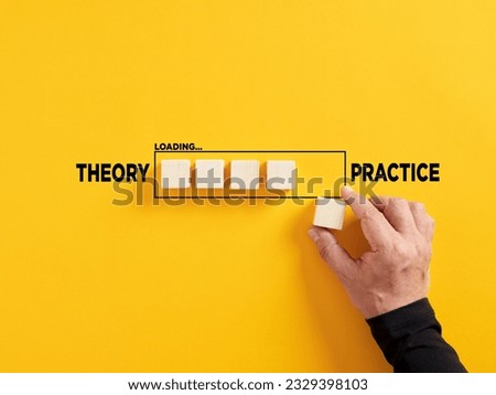 Transition of theory into practice. Implementation of theories in practice. Hand places a wooden cube to the loading bar with the words theory and practice.