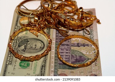 Translation of Arabic text (200 Egyptian pounds), Egyptian money and American dollars money banknotes with a set of gold accessories of rings, necklace and bracelets, gold value, sell and buy concept