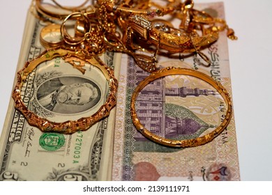 Translation of Arabic text (200 Egyptian pounds), Egyptian money and American dollars money banknotes with a set of gold accessories of rings, necklace and bracelets, gold value, sell and buy concept