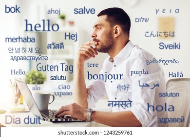 Translation, Business, And Technology Concept - Male Translator Or Businessman With Laptop Computer Thinking At Office Over Greeting Words In Different Foreign Languages