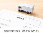 Translation: Open, Estimate, Mr., To, Co., Ltd., Tokyo, Minato-ku, Year, Month, Day, Unit Price, Quantity, Price, Hello, Best regards
A quote and truck on a desk