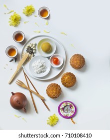 Translations on text appaer in image: Mid-autumn, Single egg yolk with Lotus seed.
Flat lay mid-autumn festival moon cake food and drink still life.