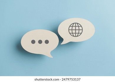 For translator application,  foreign languages concept, top view of real  white speech bubble paper with  on blue background - Powered by Shutterstock