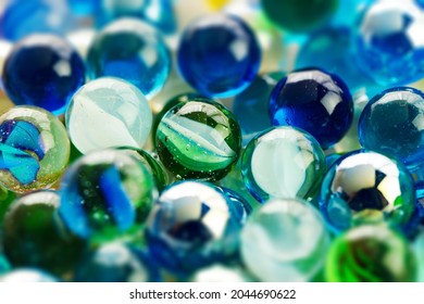 Translucent Glass Marbles On A Wold Wooden Desk. Shallow Depth Of Field.