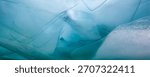 Translucent ice layers and formations appear above, with a turquoise hue, on the surface of frozen Lake Baikal. Sunlight filters through in winter.
