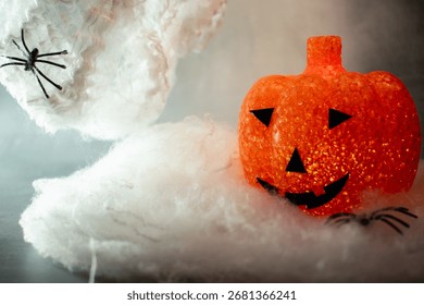 Translucent orange jack-o’-lantern with a textured bubble surface sits on artificial snow. Neutral gray background enhances its warm glow, blending Halloween charm with a hint of winter magic.