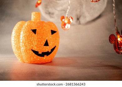 Translucent orange jack-o’-lantern with a textured bubble surface sits on artificial snow. Neutral gray background enhances its warm glow, blending Halloween charm with a hint of winter magic.