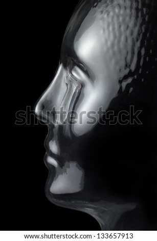 translucent reflective human head made of glass in black back