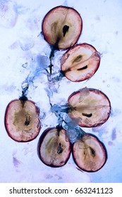 Translucent slice of red grape in blue liquid. Frozen fruit. - Shutterstock ID 663241123