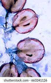 Translucent slice of red grape in blue liquid. Frozen fruit. - Shutterstock ID 663241126