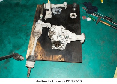 The Transmission Elements Of An All-wheel Drive Car Are Lying On The Floor In An Auto Repair Shop