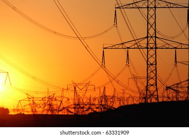 transmission tower   against the sun during sunset