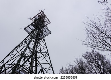 transmission tower at a mountain with gray sky in the winter - Shutterstock ID 2253853859