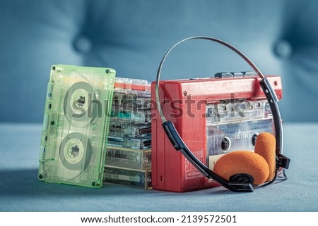 Transparent audio cassette with red player and headphones. Cassette audio tapes with a red player and headphones.