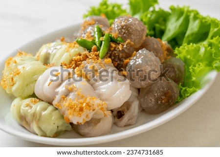 The transparent balls are called Saku Sai Moo or Steamed Tapioca Dumplings Ball with Pork Filling and ( Kow Griep Pag Mor)Pork Steamed Rice Parcels or  Steamed Rice-Skin Dumplings