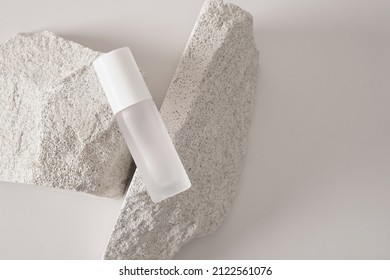 Transparent bottle of perfume on artificial stone stage on a gray background. Women's and men's essence. concise mockup perfume bottles - Shutterstock ID 2122561076