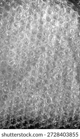 Transparent bubble wrap texture with soft reflected light. Plastic packaging material background, protective wrapping surface, abstract pattern, close up.