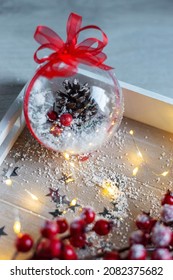 A Transparent Christmas Ball With Decor Lies In A White Wooden Box. Christmas Garland. New Year's Lighting. DIY Christmas Decorations. Christmas Background.