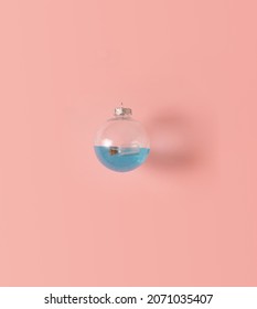 Transparent Christmas Bulb, Blue Gel And Mini Bottle Inside, Creative Composition Against Pastel Pink Background. Love Message Idea, Summer Adventure.