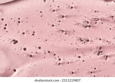Transparent cosmetic texture of serum, skin gel on a pink background, macro top view. - Shutterstock ID 2311219807