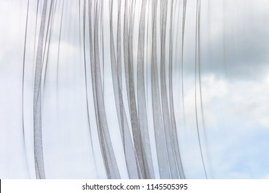 Transparent curtain in mesh patterned with background of dark and white cloudy in blue sky