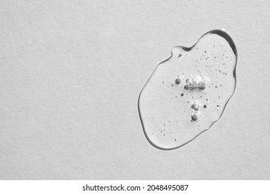 Transparent drop of moisturizing cosmetic gel with bubbles on gray background. Flat lay, place for text. - Shutterstock ID 2048495087
