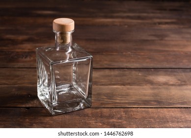 Transparent empty glass bottle on a dark background