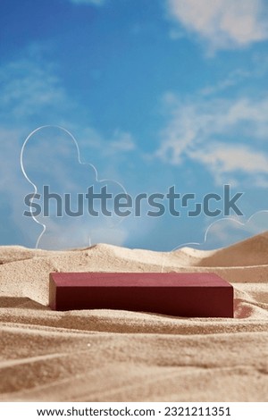 Transparent geometric shaped acrylic sheets displayed with rectangle red podium on the beach sand. Empty space on podium to show your product
