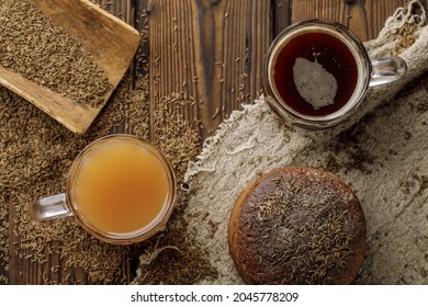 Transparent glass cup of thyme and apple organic detox drink and traditional kvass beer mug with rye bread  on rustic style wooden table. Thyme as seasoning ingredient for food and drink