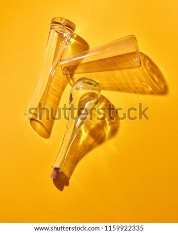 A transparent glass flasks empty lie on a yellow paper background with soft shadows, place for text. Top view. The Chemistry Lab. Various glass chemistry lab equipment. Science and medical background.