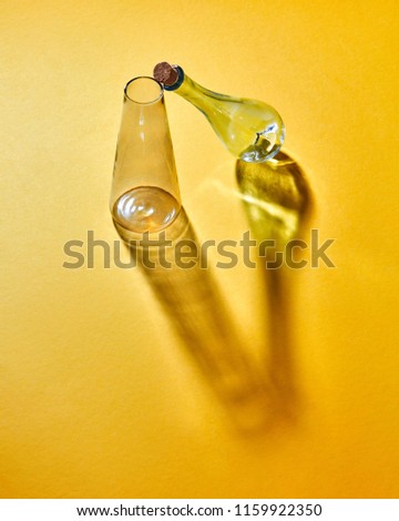 A transparent glass flasks empty on a yellow paper background with soft shadows and copy space. Laboratory glasses at experiment in chemistry laboratory.