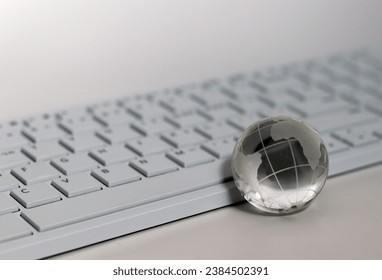 A transparent glass globe in front of the keyboard.Things and Business Concepts.