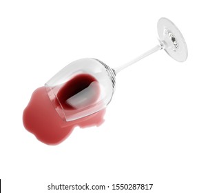 Transparent glass and spilled exquisite red wine on white background, top view